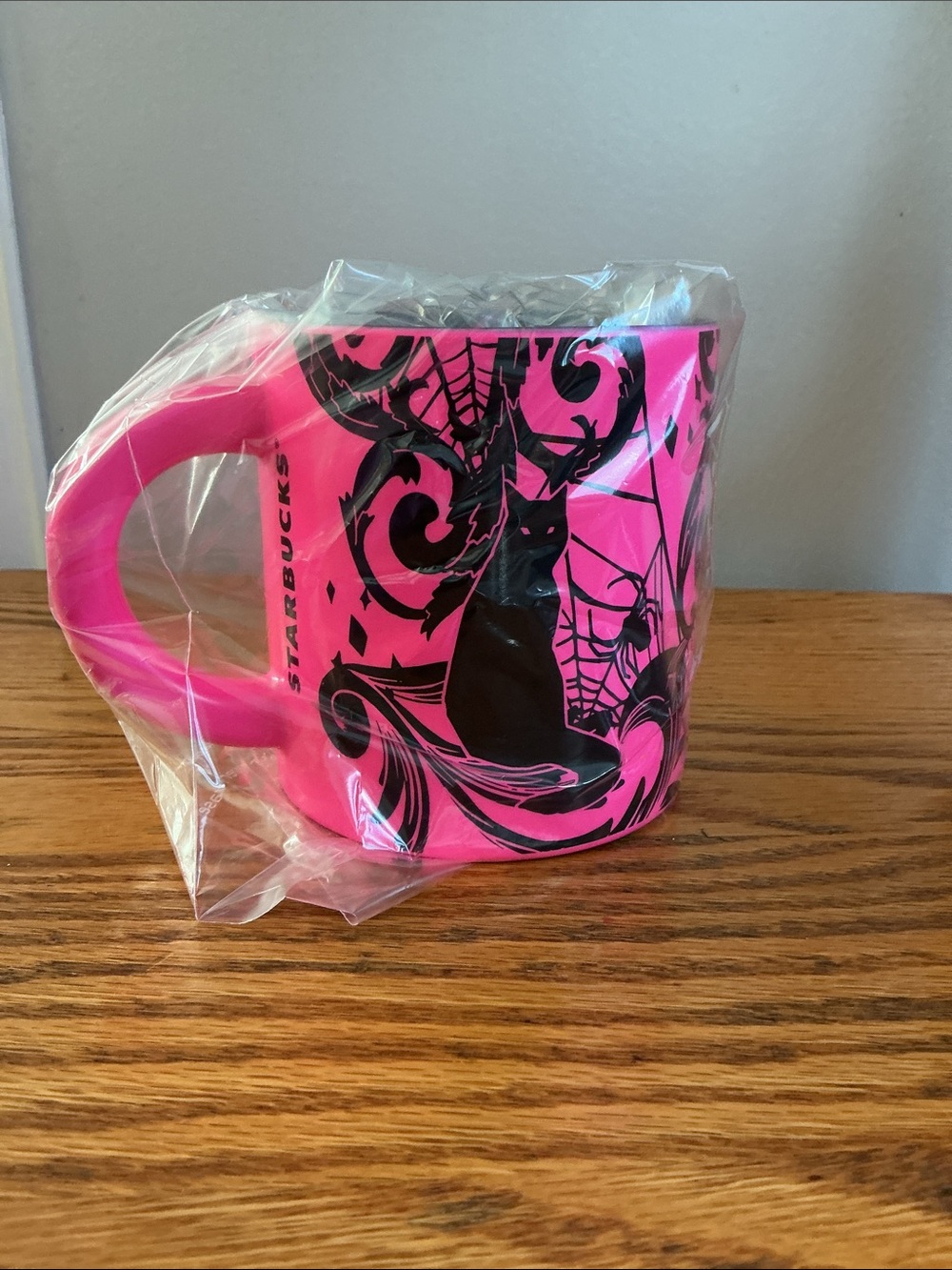 Starbucks Halloween 2021 neon pink coffee mug features a bold black cat-spider.